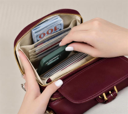 Bolso bandolera burdeos abierto con billetes y tarjetas en sus bolsillos