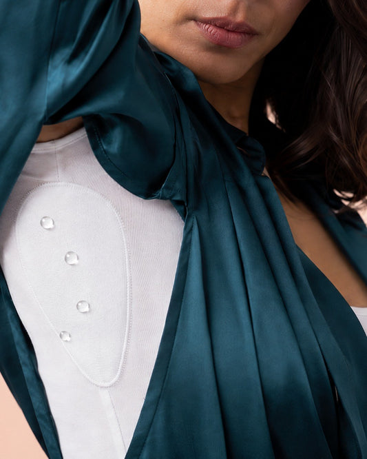 Gotas de agua sobre el panel absorbente del top Klave bajo una blusa de seda, sin traspasar a la prenda